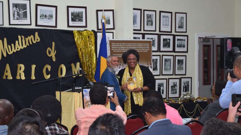 PM Mia Amor Mottley receiving a copy of Muslims of CARICOM from author Sabir Nakhuda